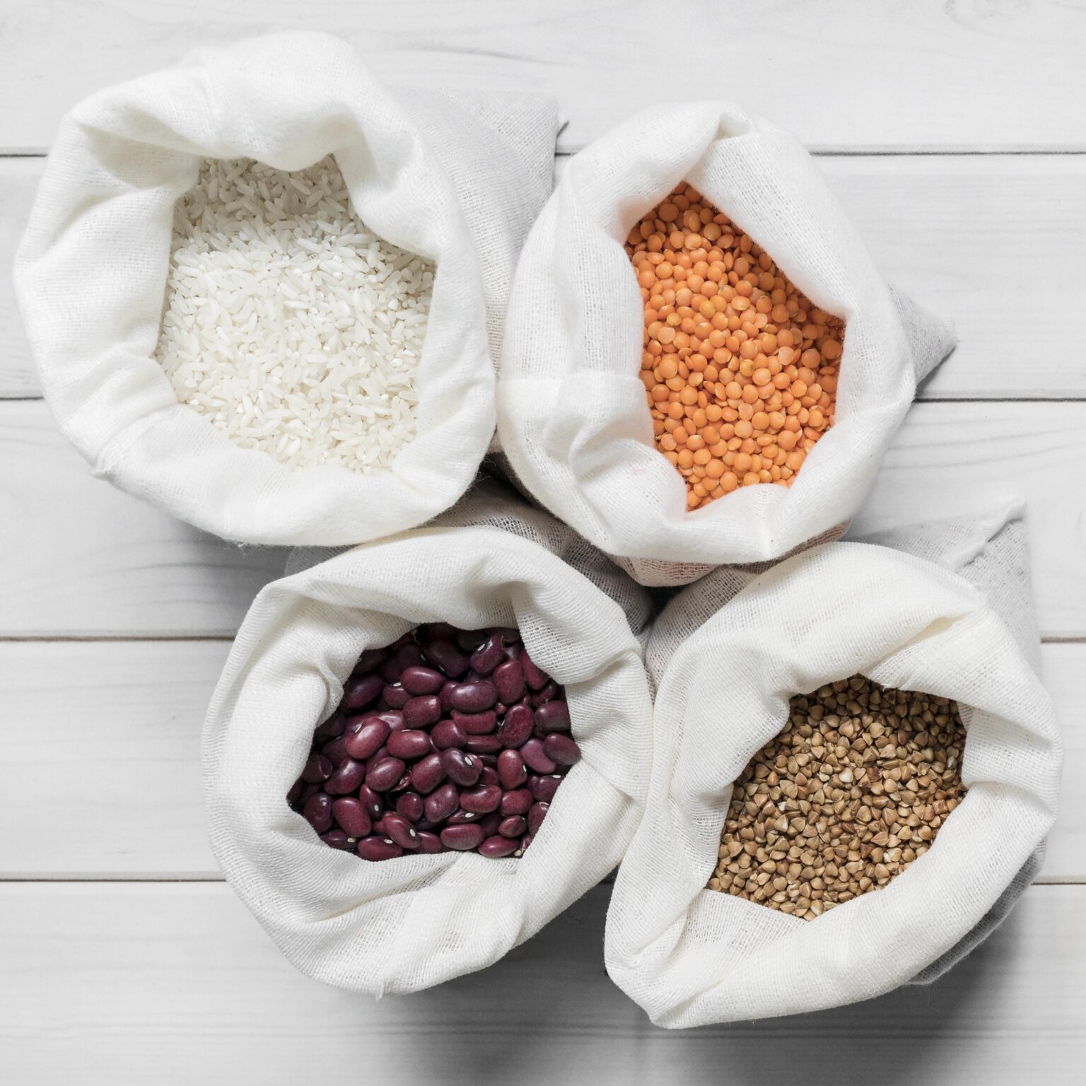 bags with different beans wooden background